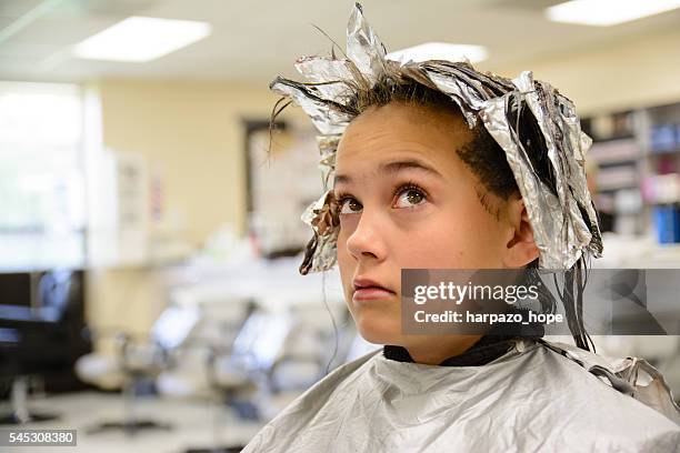 girl looking up at the foil in her hair. - tin foil hat stock-fotos und bilder