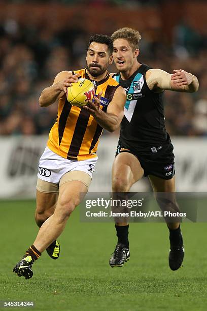 Paul Puopolo of the Hawks competes with Hamish Hartlett of the Power during the 2016 AFL Round 16 match between Port Adelaide Power and the Hawthorn...