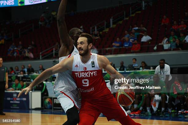 Semith Erden of Turkey protects the ball during the 2016 FIBA World Olympic Qualifying basketball Group A match between Turkey and Senegal at Mall of...