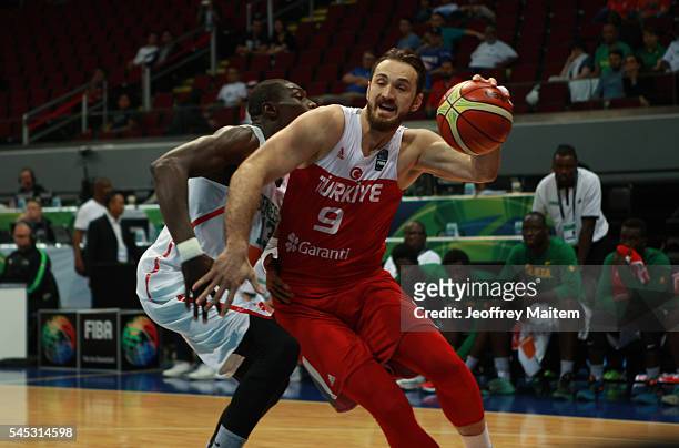 Semith Erden of Turkey protects the ball during the 2016 FIBA World Olympic Qualifying basketball Group A match between Turkey and Senegal at Mall of...