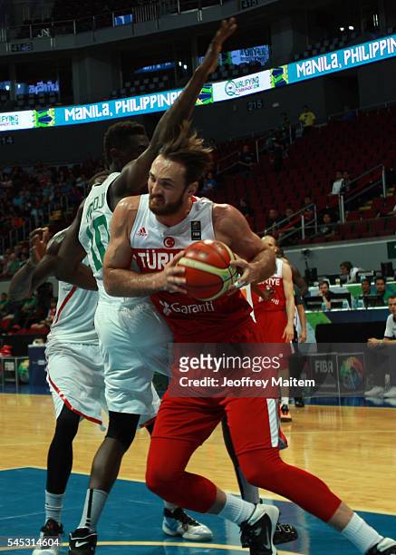 Semith Erden of Turkey protects the ball during the 2016 FIBA World Olympic Qualifying basketball Group A match between Turkey and Senegal at Mall of...