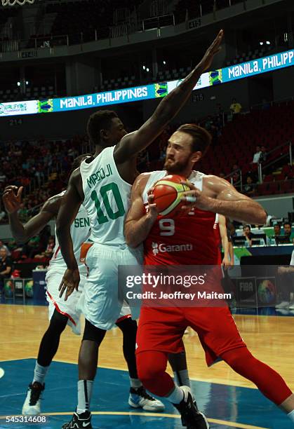 Semith Erden of Turkey protects the ball from Cheikh Mbodj of Senegal during the 2016 FIBA World Olympic Qualifying basketball Group A match between...