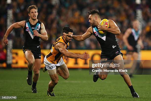 Jarman Impey of the Power fends off Paul Puopolo of the Hawks during the round 16 AFL match between the Port Adelaide Power and the Hawthorn Hawks at...