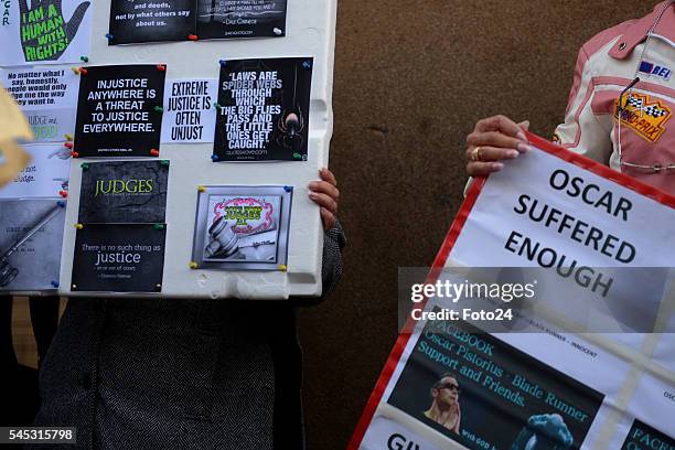 Convicted murderer Oscar Pistorius supporters carry posters written Oscar suffered enough outside the Northern Gauteng High Court after his...