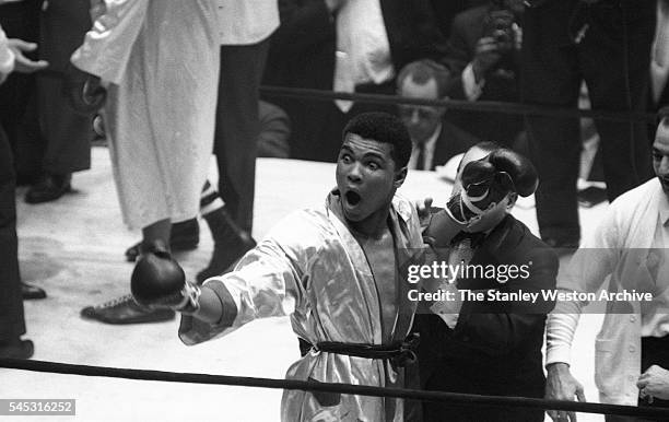 Cassius Clay celebrates his win, throwing his arms up in the air after winning the decision vs Doug Jones during their heavyweight bout at Madison...