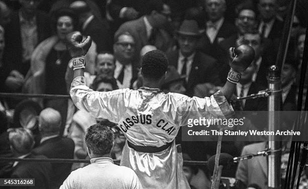 Cassius Clay celebrates his win, throwing his arms up in the air after winning the decision vs Doug Jones during their heavyweight bout at Madison...