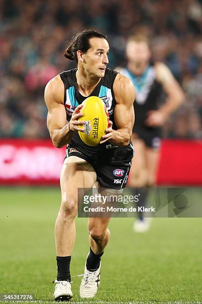 Kane Mitchell of the Power runs with the ball during the round 16 AFL match between the Port Adelaide Power and the Hawthorn Hawks at Adelaide Oval...