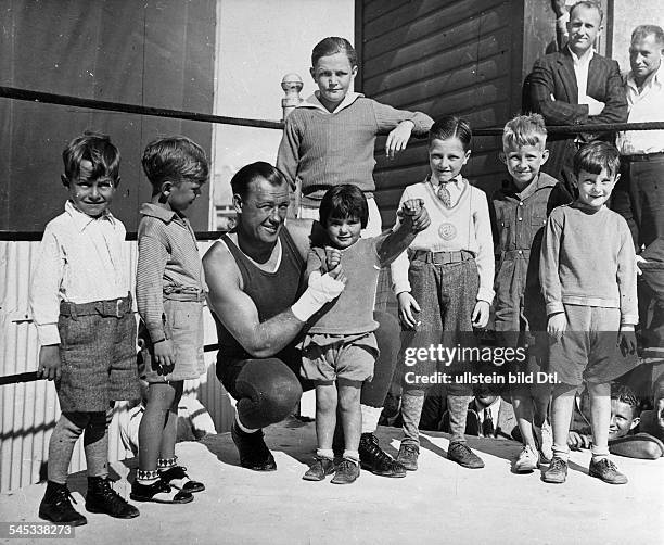 Eigentl. Joseph Paul ZukauskasSportler, Boxen USA- beim Training im Boxring umgeben Mädchen und Jungen- 1930