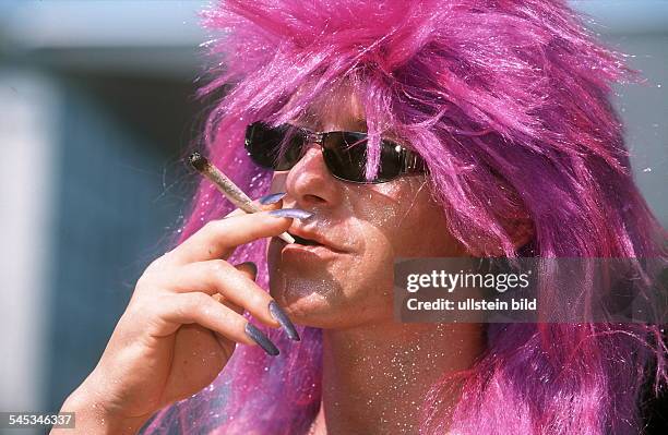 Mann mit lila Perücke und langen Fingernägeln raucht einen Joint- in Zürich 2000