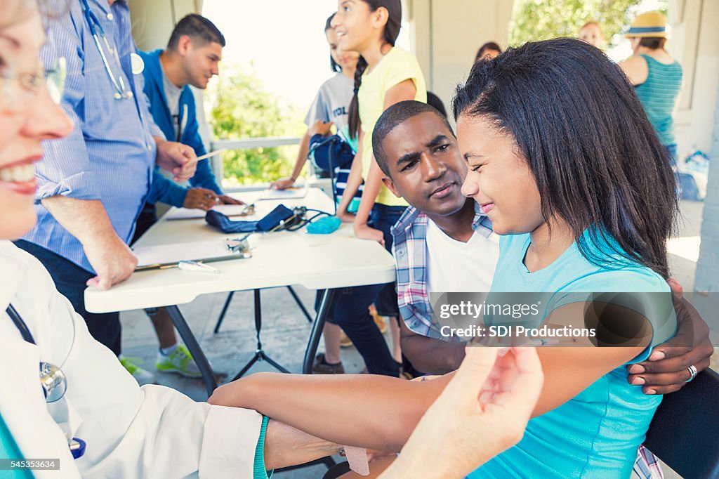 African American Girl wincing from the pain of her vaccination