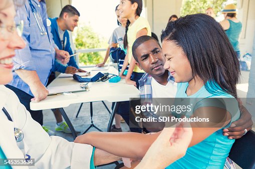African American Girl wincing from the pain of her vaccination African American Girl wincing from the pain of her vaccination