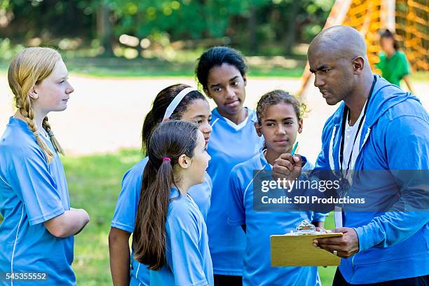 african american soccer coach giving pep talk to his team - team talk stockfoto's en -beelden