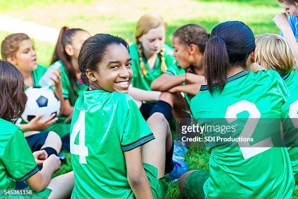 belle fille afro-américaine souriant avec son équipe de football - terme sportif photos et images de collection