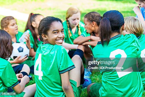 beautiful african american girl smiling with her soccer team - playing sports stock pictures, royalty-free photos & images