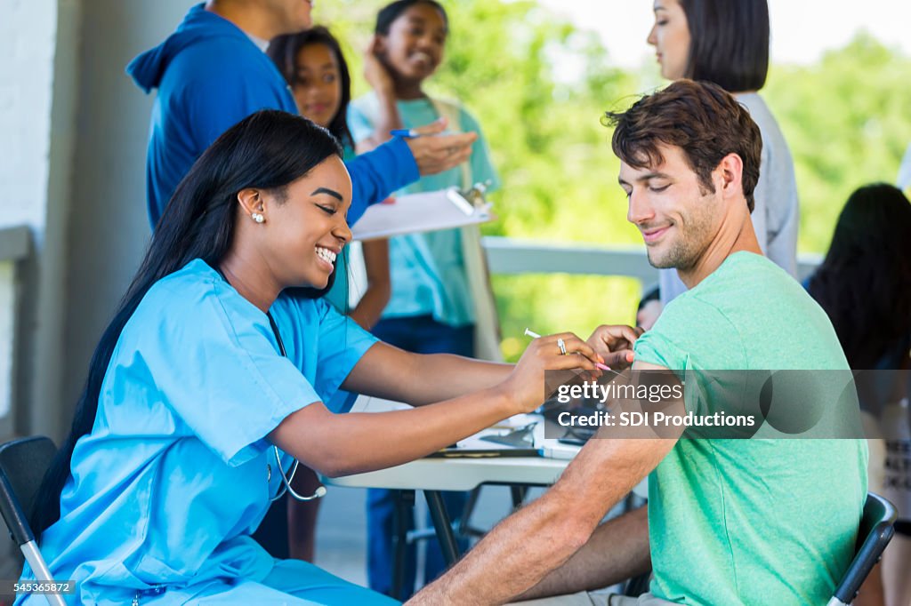 Man receives immunization at outdoor free clinic