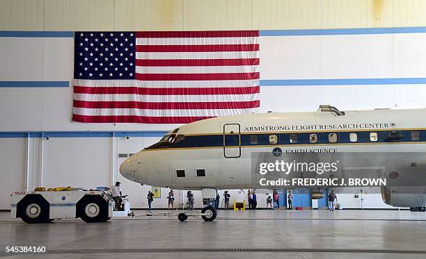 S highly modified Douglas DC-8 jetliner which operates as a flying science laboratory is brought into a hangar at the Armstrong Flight Research...