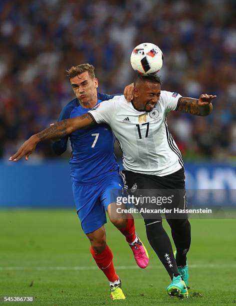 Jerome Boateng of Germany heads the ball under pressure from Antoine Griezmann of France during the UEFA EURO semi final match between Germany and...
