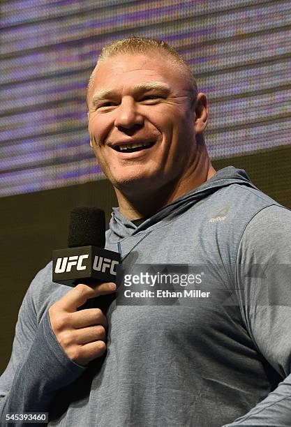 Mixed martial artist Brock Lesnar smiles as he takes questions from members of the media during an open workout for UFC 200 at T-Mobile Arena on July...