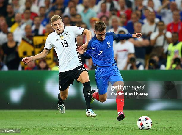 Antoine Griezmann of France runs with the ball under pressure from Toni Kroos of Germany during the UEFA EURO semi final match between Germany and...