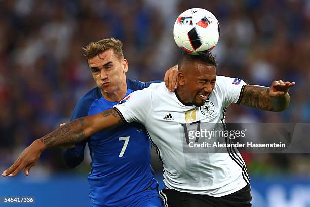 Jerome Boateng of Germany heads the ball under pressure from Antoine Griezmann of France during the UEFA EURO semi final match between Germany and...