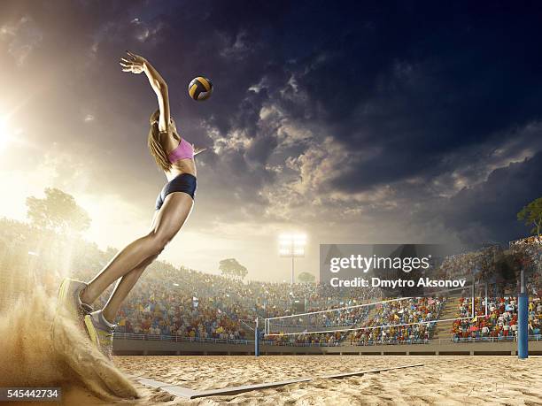 weibliche volleyball-spieler in aktion  - junge frau strand sand springen stock-fotos und bilder