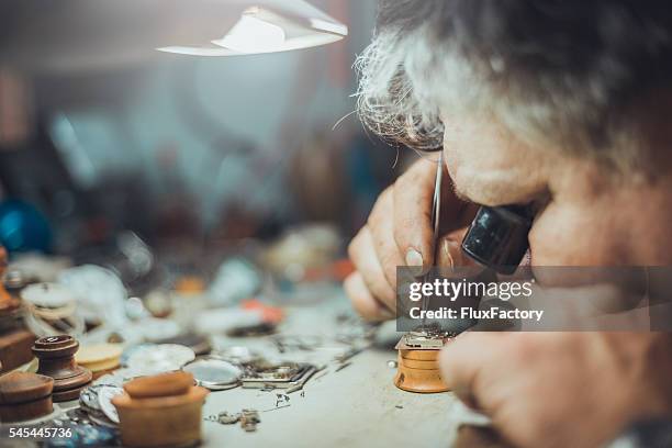 watchmaker repairs watch - picking parts with tweezers - vintage jewellery stock pictures, royalty-free photos & images