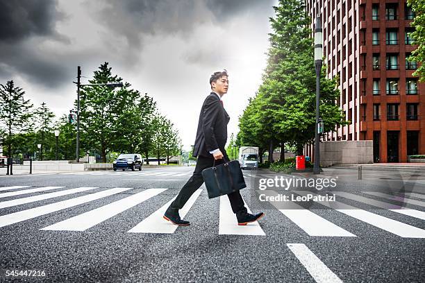 japanese business man in tokyo financial district - pedestrian crossing man stock pictures, royalty-free photos & images