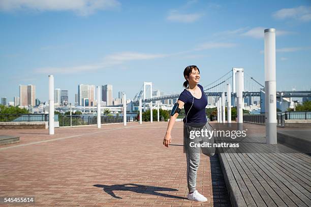 japanese woman stretching - jogster stockfoto's en -beelden