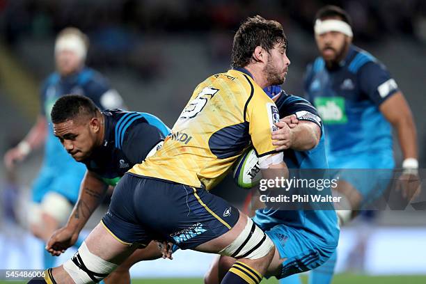 Sam Carter of the Brumbies is tackled by Jerome Kaino of the Blues during the round 16 Super Rugby match between the Blues and the Brumbies at Eden...