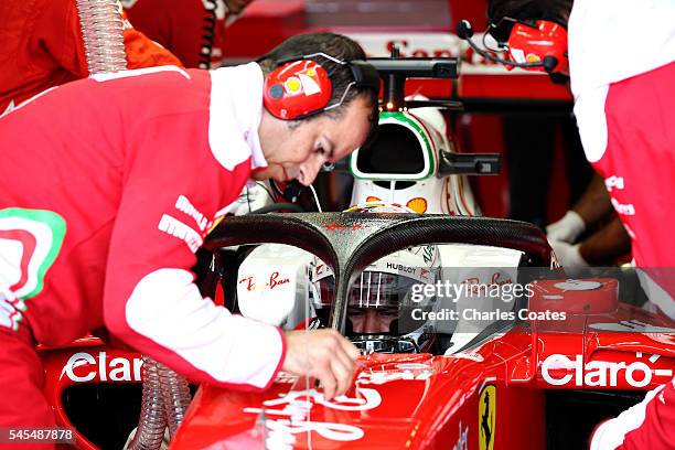 Sebastian Vettel of Germany and Ferrari sits in his car in the garage with the halo fitted during practice for the Formula One Grand Prix of Great...