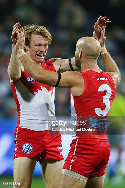 Callum Mills of the Swans celebrates a goal with Jarrad McVeigh during the round 16 AFL match between the Geelong Cats and the Sydney Swans at...