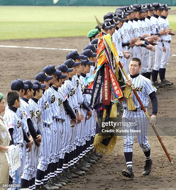 Japan - Hirotsugu Sato, captain of Tokaidai Sagami in Kanagawa Prefecture, carries the champion flag at Koshien Stadium in Hyogo Prefecture on April...