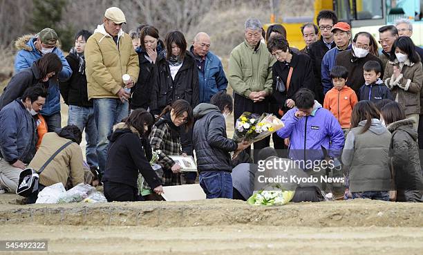 Japan - People bid farewell to a victim of the March 11 earthquake and tsunami at the city-run cemetery in Higashimatsushima, Miyagi Prefecture, on...