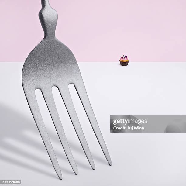 oversized fork and tiny cupcake - perspective artificielle photos et images de collection