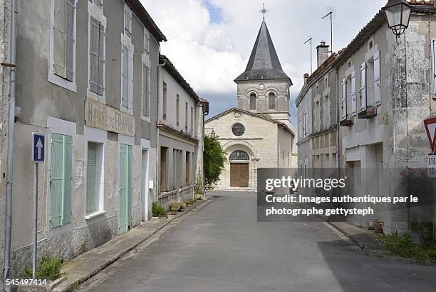 the main street of salle-lavalette in front of catholic church - charente foto e immagini stock