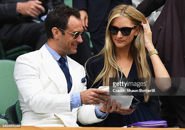 Jude Law and Phillipa Coan watch on as Roger Federer of Switzerland plays Milos Raonic of Canada in the Men's Singles Semi Final match on day eleven...
