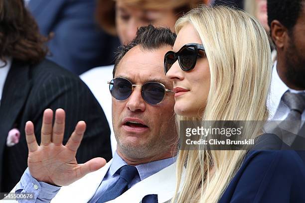 Jude Law and Phillipa Coan watch on as Roger Federer of Switzerland plays Milos Raonic of Canada in the Men's Singles Semi Final match on day eleven...