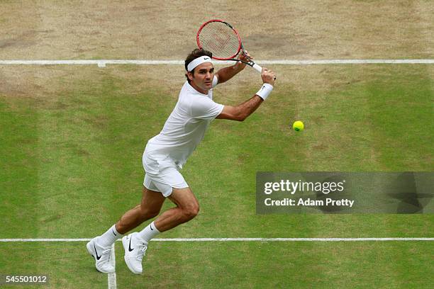 Roger Federer of Switzerland plays a backhand during the Men's Singles Semi Final match against Milos Raonic of Canada on day eleven of the Wimbledon...