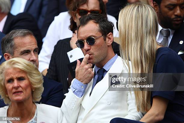 Jude Law and Phillipa Coan watch on as Roger Federer of Switzerland plays Milos Raonic of Canada in the Men's Singles Semi Final match on day eleven...