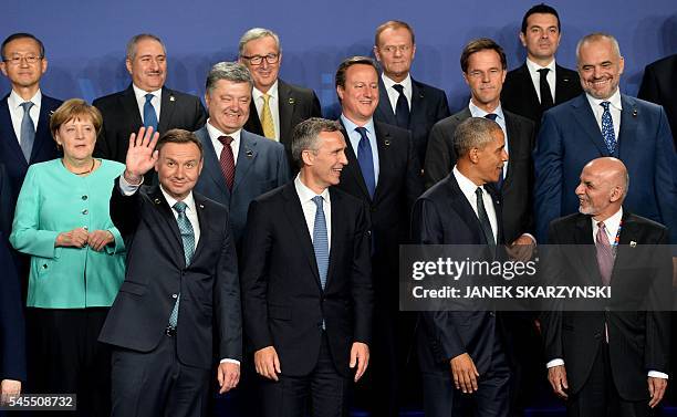 Polish President Andrzej Duda waves as he poses for a family photo next to NATO Secretary General Jens Stoltenberg , US President Barack Obama ,...