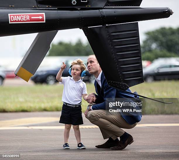 Prince George points up at the tail rotor of a "Squirrel" helicopter similar to the one that his father Prince William, Duke of Cambridge trained on...