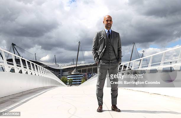 Manchester City's manager Pep Guardiola poses for photographs outside the Etihad Stadium on July 8, 2016 in Manchester, England.