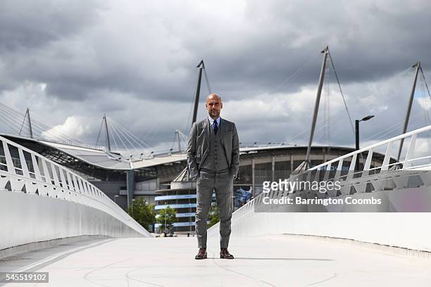 Manchester City's manager Pep Guardiola poses for photographs outside the Etihad Stadium on July 8, 2016 in Manchester, England.