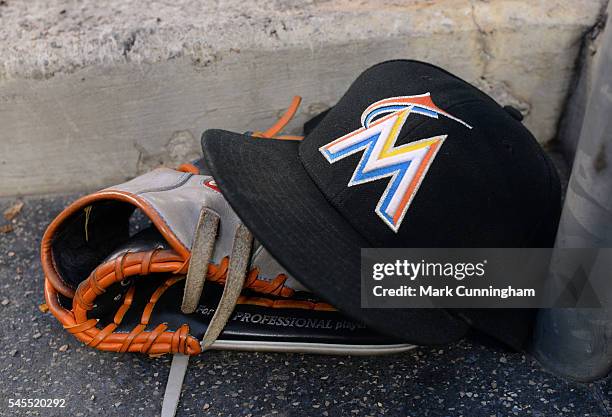 Detailed view of a Miami Marlins baseball hat and glove sitting on the dugout steps during the game against the Detroit Tigers at Comerica Park on...