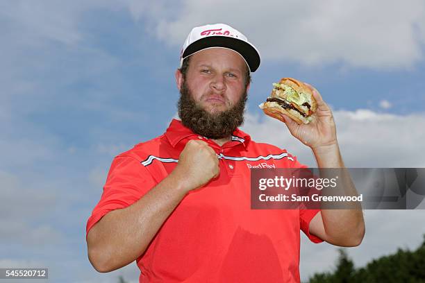 Andrew Johnston of England poses for a portrait with a hamburger after the third round of the World Golf Championships - Bridgestone Invitational at...