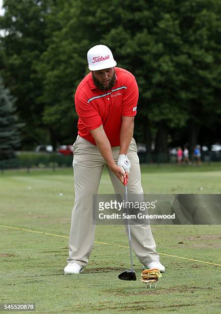 Andrew Johnston of England swings at a teed up hamburger during a portrait session after the third round of the World Golf Championships -...