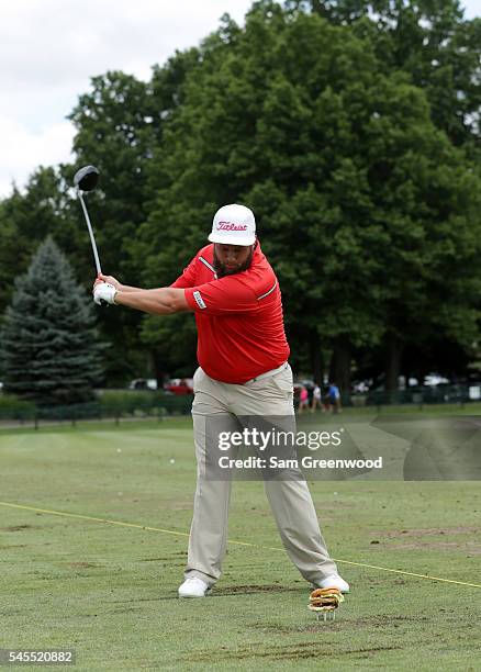 Andrew Johnston of England swings at a teed up hamburger during a portrait session after the third round of the World Golf Championships -...