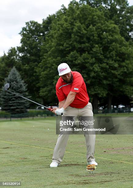 Andrew Johnston of England swings at a teed up hamburger during a portrait session after the third round of the World Golf Championships -...