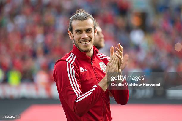 Wales' Gareth Bale applauds the crowd during a ceremony at the Cardiff City Stadium on July 8, 2016 in Cardiff, Wales. The players toured the streets...