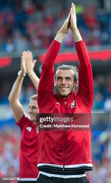 Wales' Gareth Bale applauds the crowd during a ceremony at the Cardiff City Stadium on July 8, 2016 in Cardiff, Wales. The players toured the streets...